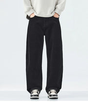 Person wearing black wide-leg pants with a plain background