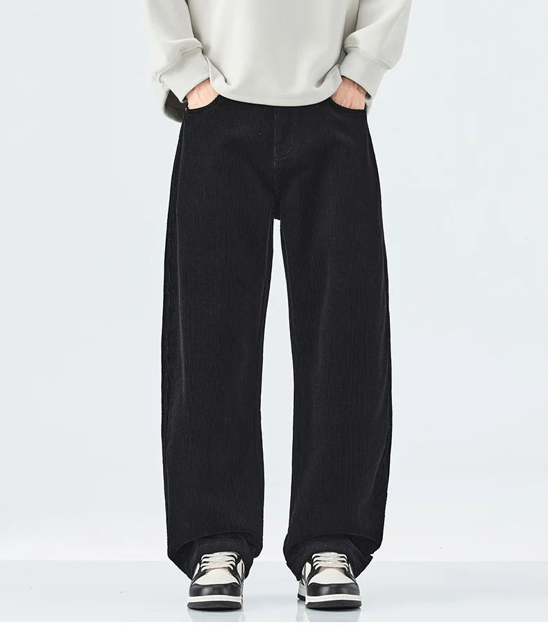 Person wearing black wide-leg pants with a plain background