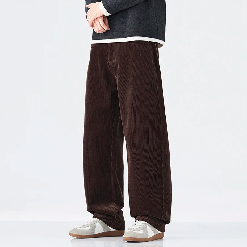 Brown corduroy pants worn by a person on a white background