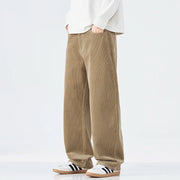Person wearing beige corduroy pants and white sneakers on a white background