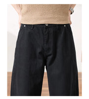 Close-up of a person wearing black wide-leg pants and a beige knit top