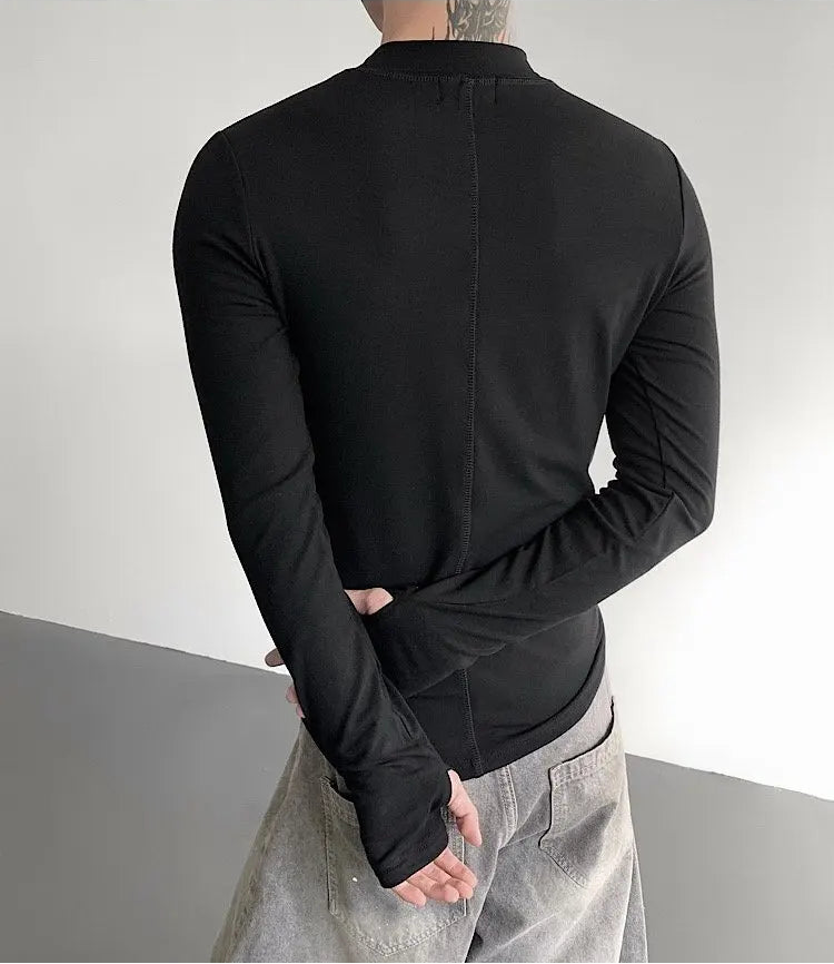 Person wearing a black long-sleeve shirt with a gray background