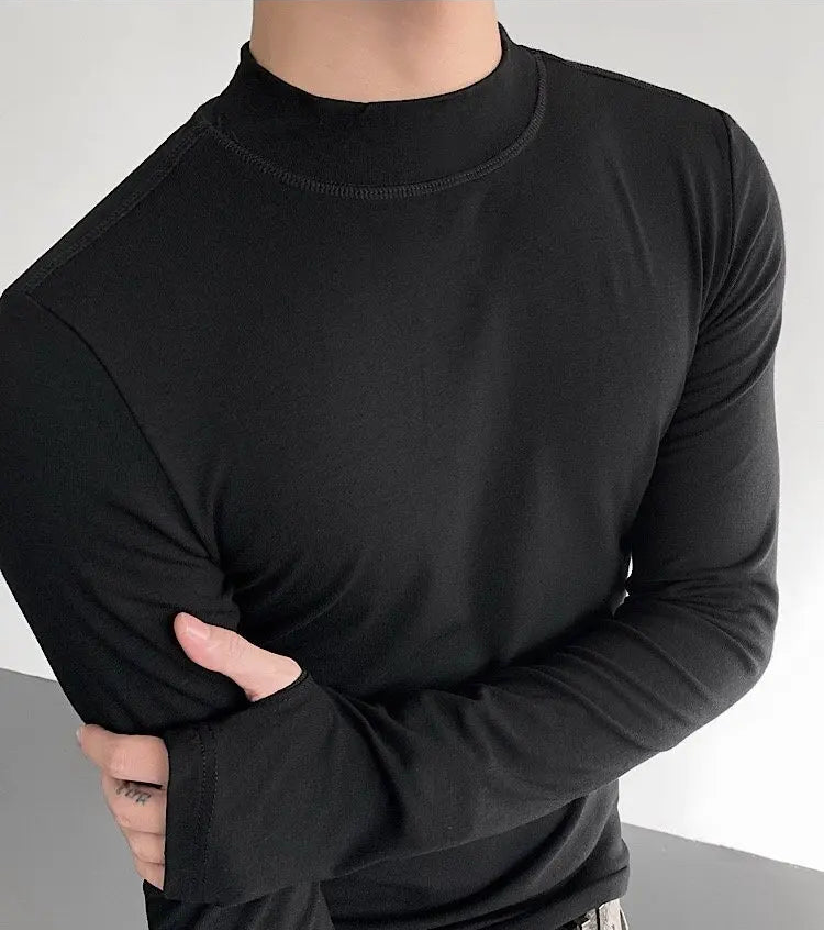 Person wearing a black long-sleeve shirt against a neutral background