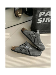 Gray sandals with cork sole on a white floor