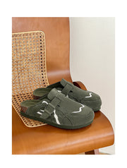 Green slippers with velcro straps on a brown chair