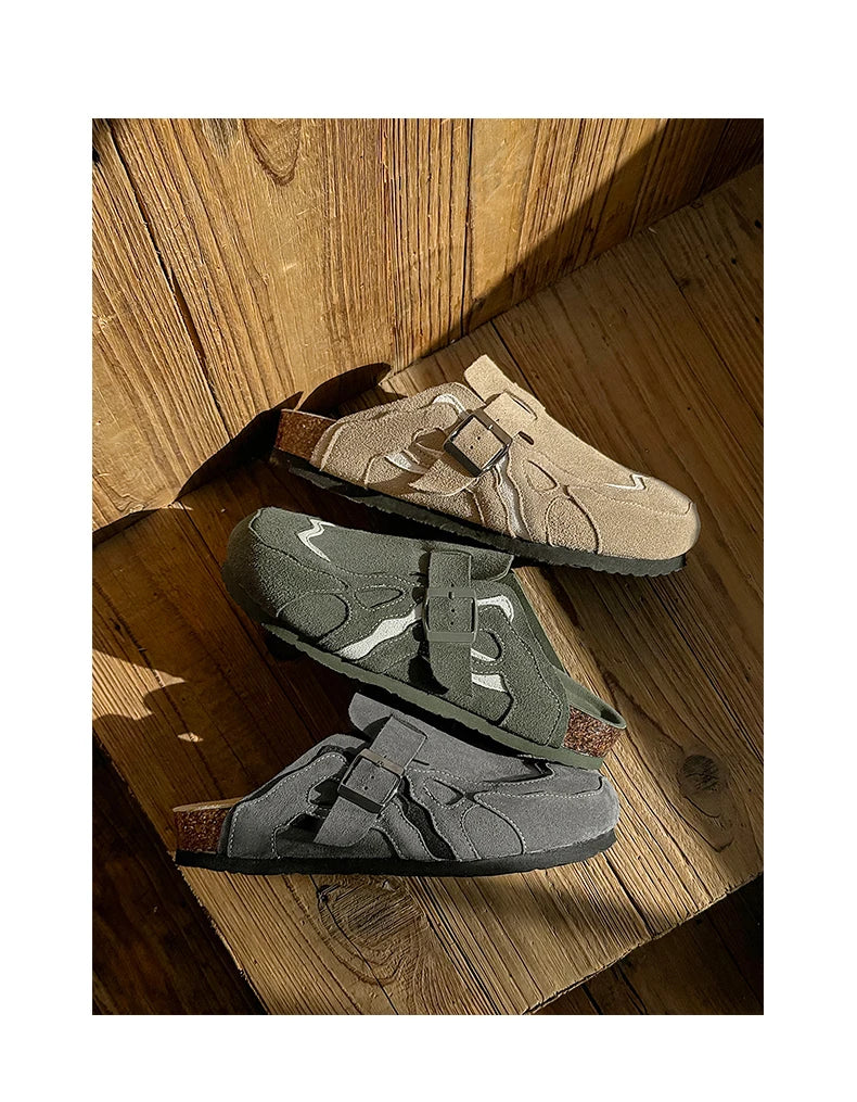 Two pairs of shoes on a wooden floor with sunlight casting shadows.