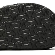 Close-up of a black shoe sole with a textured pattern on a white background