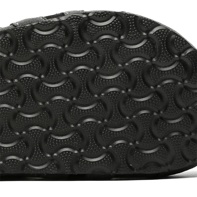 Close-up of a black shoe sole with a textured pattern on a white background