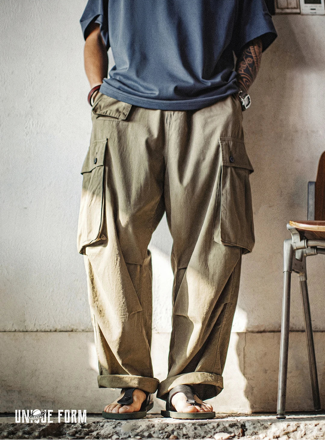 Person wearing beige cargo pants and a blue shirt in an indoor setting.