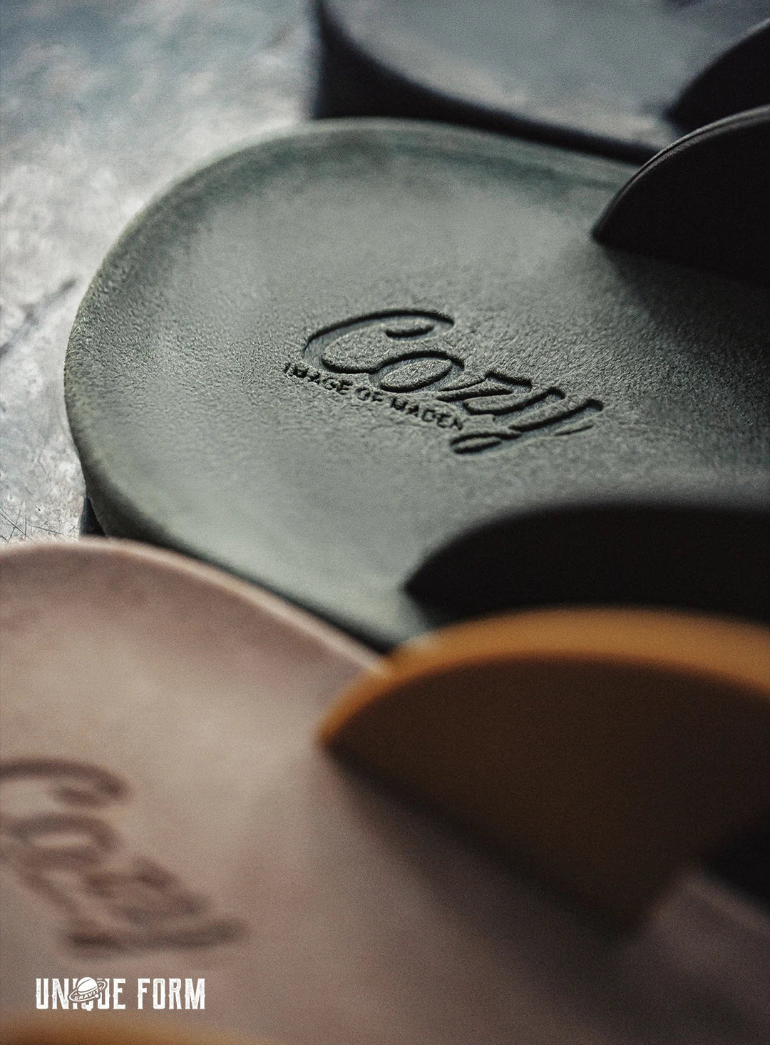 Close-up of Cozy brand leather products on a textured surface