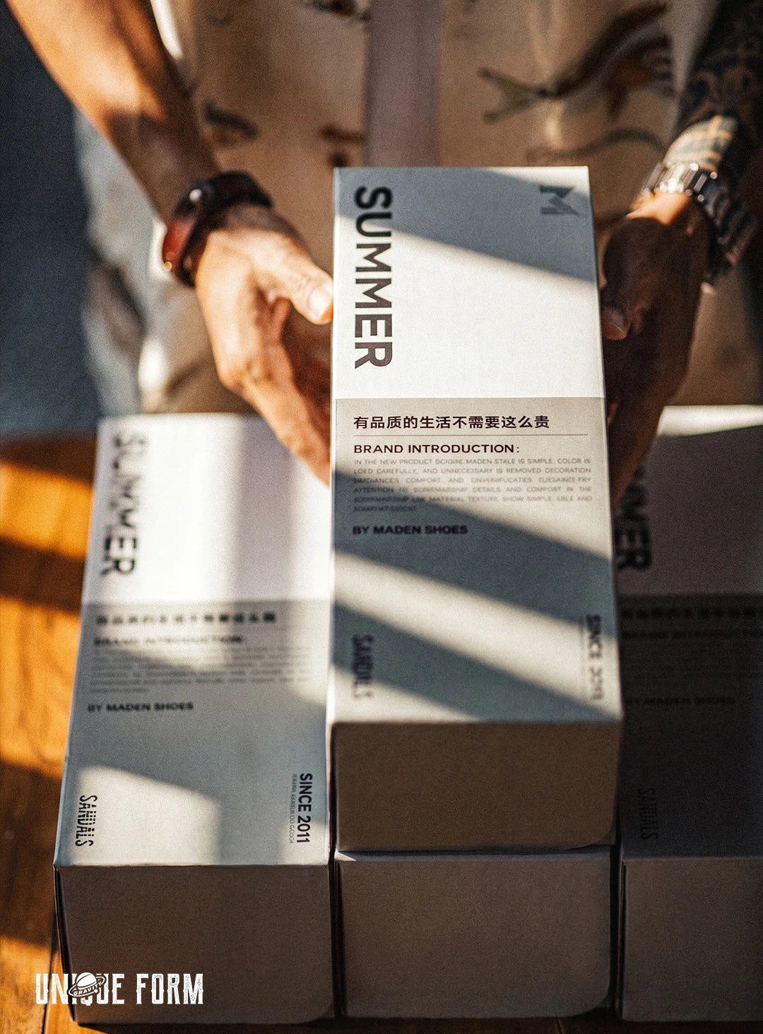 Stack of 'Summer' shoe boxes with branding and text.