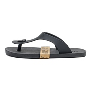A single black thong sandal with a small black heart detail on the strap, shown from the side against a plain white background. A tan paper band is wrapped around the midsole.