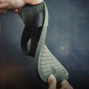 Person holding a green sandal.