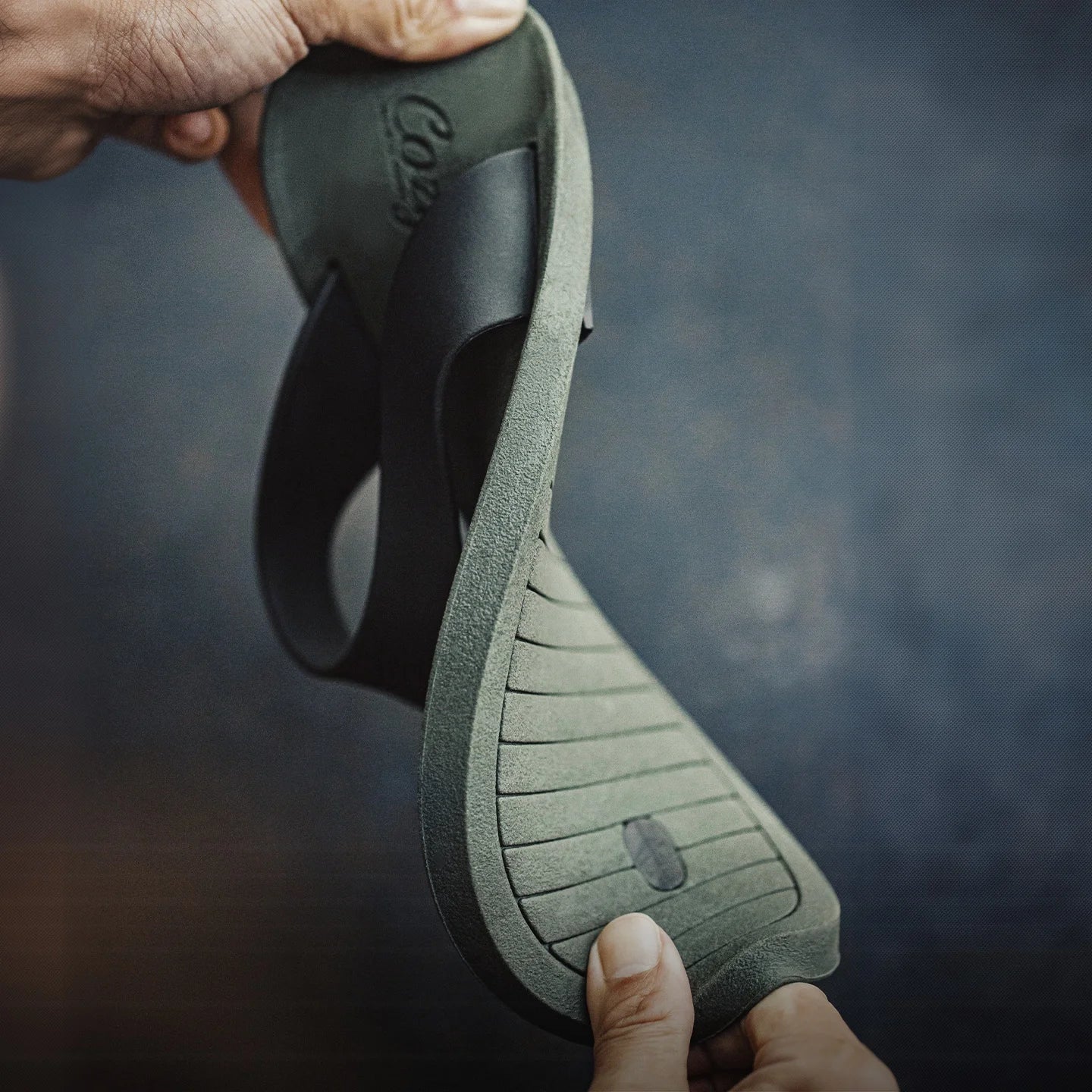 Person holding a green sandal.
