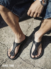 Person wearing black sandals on a concrete surface with 'UNIQUE FORM' branding.